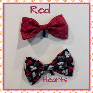 May include: Two bow ties, one red with a white swirl pattern and the text "Red", and the other black with a white and red heart pattern and the text "Hearts".