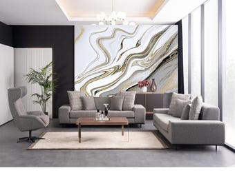 Puede incluir: Un interior de sala de estar con dos sofás grises, una mesa de centro y un sillón gris. La pared detrás de los sofás presenta un gran mural de pared abstracto con patrones de remolino blancos, dorados y negros.