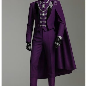 May include: A formal purple suit with a matching cape, vest, and trousers. The suit features ornate silver embellishments and a high collar. The mannequin is wearing black gloves, rings, and boots. The outfit is displayed on a gray background.