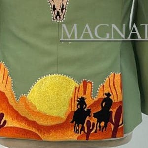 May include: Olive green jacket with embroidered desert scene featuring cowboys, cacti, and a yellow sun. The word "MAGNATE" is printed on the jacket. The jacket has a decorative pattern at the top.