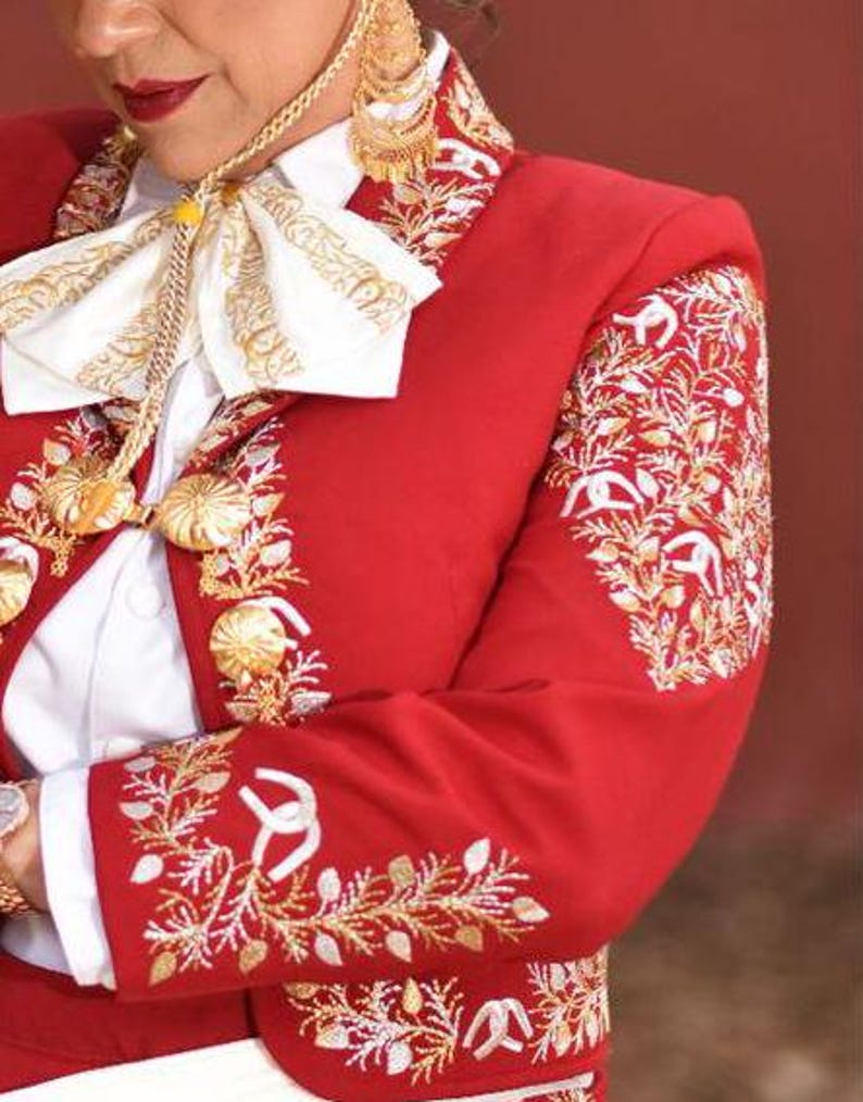 May include: A red embroidered jacket with gold and white thread. The jacket has a white shirt underneath and a white bow tie with gold embroidery.