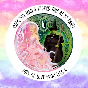 May include: A circular design with characters from the musical "Wicked" set against a rainbow background. The text reads "HOPE YOU HAD A WICKED TIME AT MY PARTY" and "LOTS OF LOVE FROM LISA X".