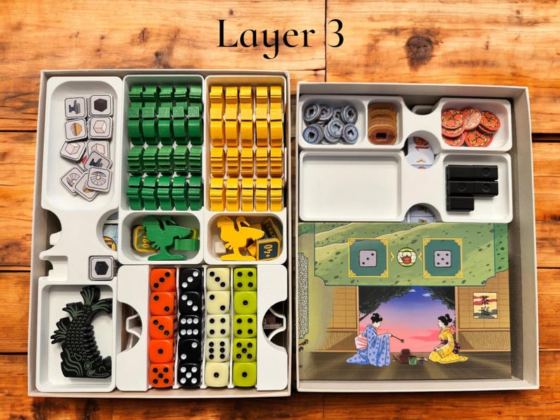May include: A white plastic organizer with multiple compartments for storing game pieces. The organizer is labeled "Layer 3". The compartments contain various colored plastic pieces, dice, and a small illustration of a fish.