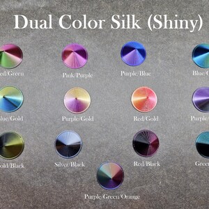 May include: A collection of 14 dual color silk fabric samples, each with a different color combination. The samples are arranged in a grid pattern and labeled with the color combinations, such as "Red/Green", "Pink/Purple", "Purple/Blue", "Blue/Green", "Blue/Gold", "Purple/Gold", "Red/Gold", "Purple/Black", "Gold/Black", "Silver/Black", "Red/Black", "Green/Black", and "Purple/Green/Orange".