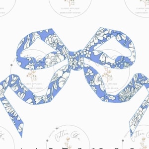 Puede incluir: Un lazo azul con un patrón floral blanco. El lazo está atado en un nudo y los extremos están rizados.