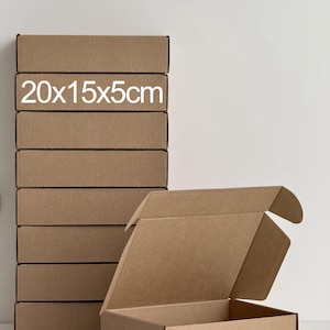Könnte beinhalten: Eine Reihe brauner Versandkartons, eine davon geöffnet. Die rechteckigen Kartons messen 20x15x5cm, wie auf den Kartons angegeben. Sie bestehen aus Wellpappe.