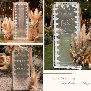 May include: A transparent wedding welcome sign with white lace trim and brown ribbon accents. The sign displays names and dates, surrounded by pampas grass and floral arrangements. The sign reads "Welcome to the Wedding of Amelia & James 05.08.2026".