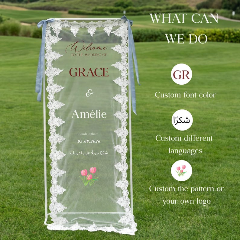 May include: A white wedding sign with lace trim and blue ribbons. The sign reads "Welcome to the wedding of Grace & Am&eacute;lie" with the date 05.08.2026. Additional text includes "What can we do" and options for customization.