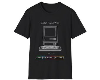 Puede incluir: Camiseta negra con un contorno blanco de una computadora Apple Macintosh 128K de 1984. El texto "KEEPING THESE VINTAGE TECHNOLOGIES ALIVE" y "FOR(RETRO)[LOOP]" está impreso en la camiseta.