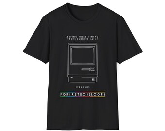 Puede incluir: Camiseta negra con un dibujo lineal blanco de un ordenador vintage. El texto "KEEPING THESE VINTAGE TECHNOLOGIES ALIVE" está encima del gráfico del ordenador. Debajo, se lee "1986 PLUS" y "FOR{RETRO}{LOOP}" en una barra arcoíris.