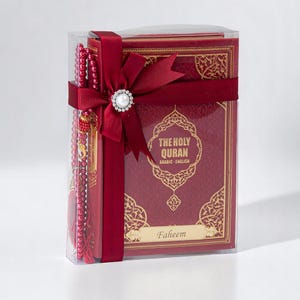 May include: A boxed set featuring a burgundy-colored Quran with gold filigree, a matching prayer bead strand, and a decorative bow with a pearl-centered embellishment. The text on the cover reads "THE HOLY QURAN ARABIC - ENGLISH" and includes the name "Faheem".