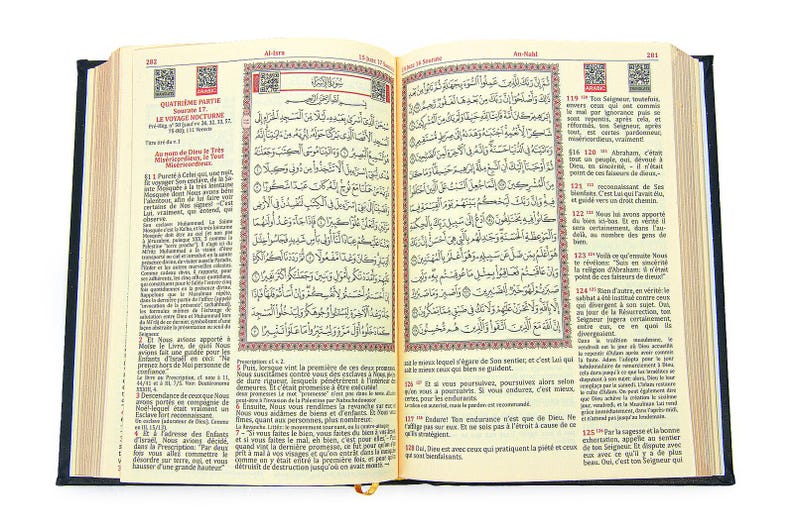 May include: An open book with Arabic script and French translation. The pages are cream-colored with black text and red accents. The book has a dark blue cover and a gold ribbon bookmark.