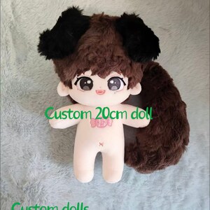 May include: A custom 20cm doll with brown hair and a black dog costume. The doll has a pink candy design on its chest and a brown tail.