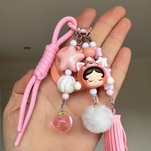 キラキラ輝く本物のPopmart Skullpandaパンダポップビーンビーズ携帯ストラップとバッグチャームキーリング（ピンク）