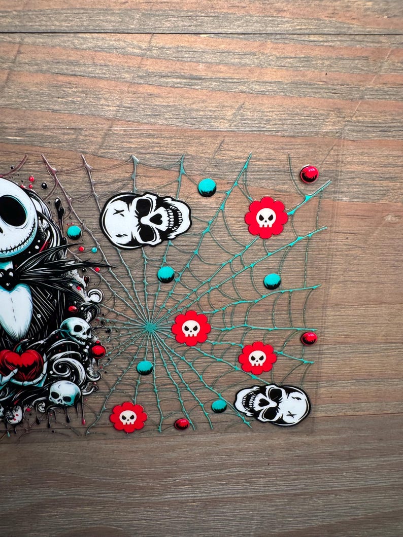 Puede incluir: Una pieza decorativa rectangular transparente con tem&aacute;tica de Halloween. El dise&ntilde;o incluye una telara&ntilde;a con l&iacute;neas turquesas, calaveras rojas con forma de flor, puntos turquesas y rojos, y gr&aacute;ficos de calaveras.