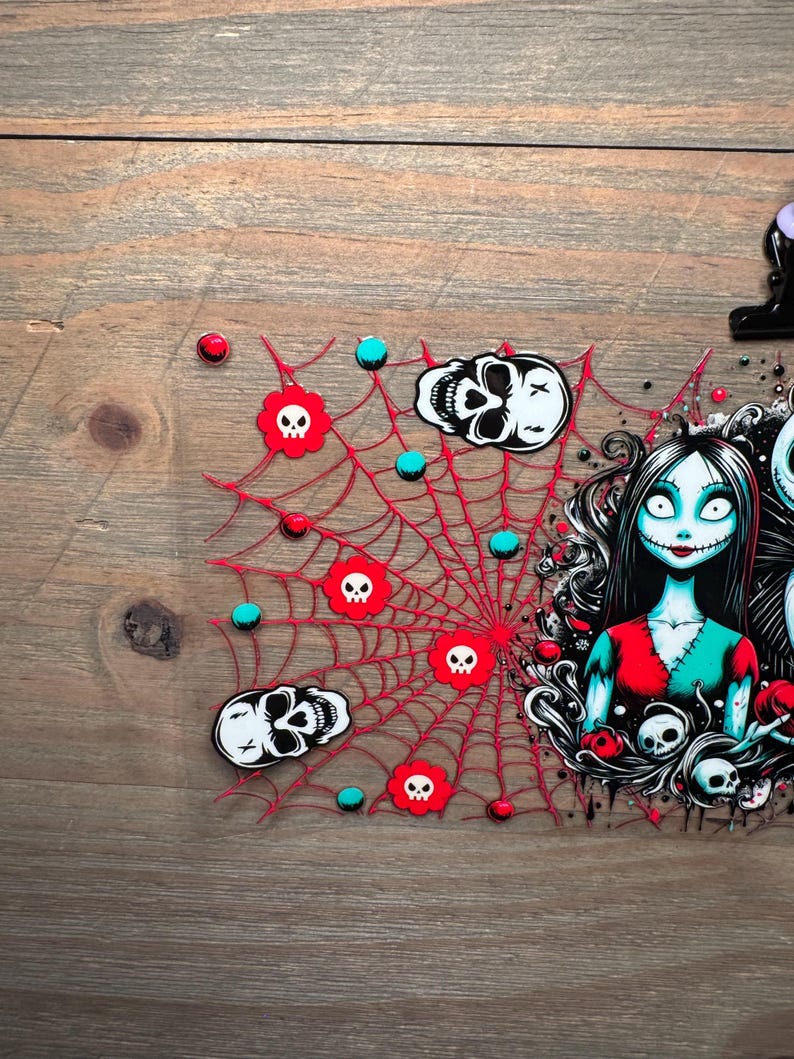 Puede incluir: Un dise&ntilde;o tem&aacute;tico de Halloween con una telara&ntilde;a roja con detalles de calaveras y orbes turquesas. El dise&ntilde;o tambi&eacute;n incluye un personaje con cabello negro, ropa roja y turquesa y un dise&ntilde;o tem&aacute;tico de calaveras. El fondo es una veta de madera.