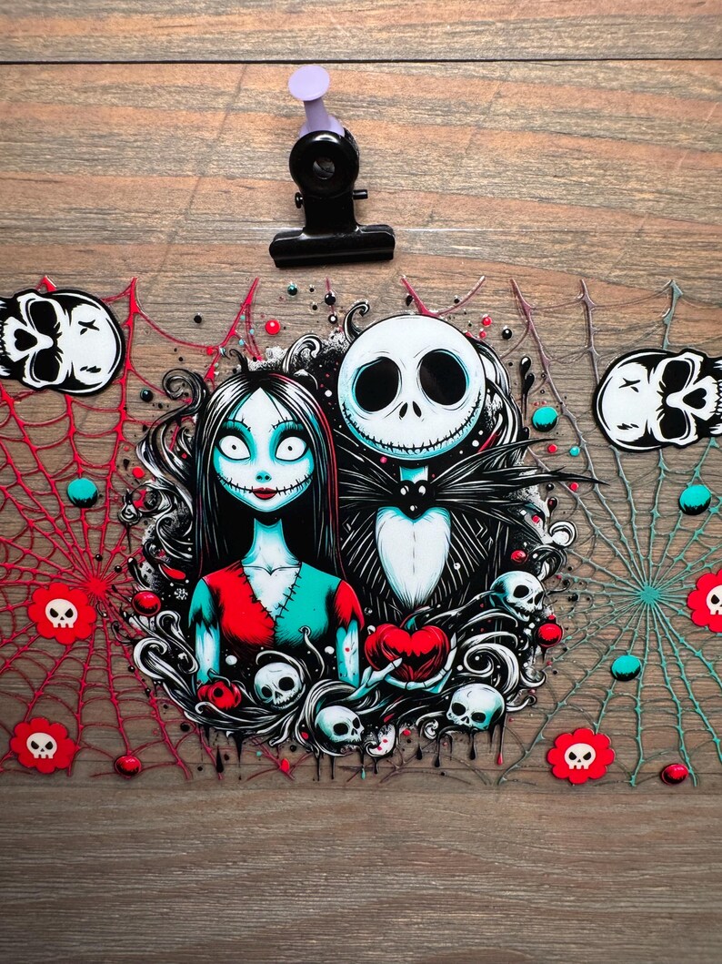 Puede incluir: Ilustraci&oacute;n con tem&aacute;tica de Halloween con Jack Skellington y Sally de Pesadilla antes de Navidad. La obra de arte incluye calaveras, telara&ntilde;as y un coraz&oacute;n. La paleta de colores incluye rojo, negro, blanco y verde azulado.