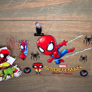 K&ouml;nnte beinhalten: Eine Sammlung von Spider-Man-Aufklebern und Grafiken. Das Hauptbild zeigt einen gro&szlig;en, cartoonartigen Spider-Man in einer dynamischen Pose mit den Worten "Marvel Spider-Man Homecoming". Zus&auml;tzliche Aufkleber enthalten Spider-Man-Logos und andere Charakterdesigns.