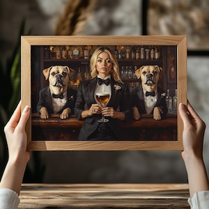 May include: A framed print depicts a woman and two dogs behind a bar, all wearing formal attire. The woman holds a glass of beer. The dogs and woman are in black suits with bow ties. The bar has bottles of liquor on the shelves.