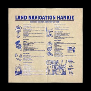 May include: A tan handkerchief with blue text and illustrations. The text reads "Land Navigation Hankie" and "Know Your Direction, Know Your Way Home." Illustrations include a compass, footprints, and a sun. It also has cardinal directions.