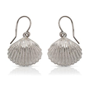 May include: Silver shell shaped dangle earrings. The earrings are made of sterling silver and have a delicate, textured finish.