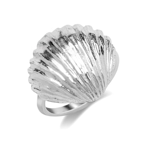 May include: A silver ring shaped like a seashell. The ring has a detailed, textured design.