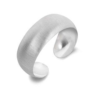 May include: A silver-toned cuff ring with a brushed metal finish. The ring has a curved, open design, with rounded ends. The metal has a subtle texture, and the ring is set against a white background.