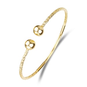 Könnte beinhalten: Ein goldenes Armreif-Armband mit einem strukturierten Design und zwei runden Kugelakzenten an den Enden.