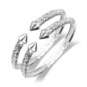 May include: Two silver-toned, open-ended bracelets. Each bracelet features a decorative, textured band with a floral pattern. The ends of each bracelet are pointed, with a conical shape. The bracelets are displayed on a white background.