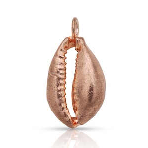 May include: A rose gold cowrie shell charm pendant. The shell is open and has a smooth, polished finish.