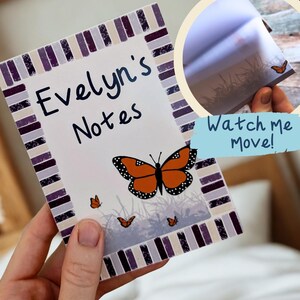 May include: A notepad featuring the text "Evelyn's Notes" and a butterfly design. The notepad has a white background with a purple and grey border. The butterfly is orange and black. The image also includes the text "Watch me Move!"