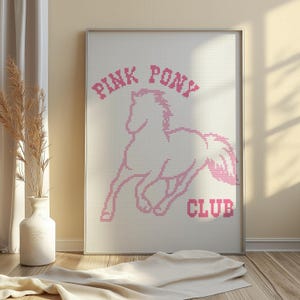 Peut inclure: Un dessin de point de croix encadré avec un poney rose et le texte "Pink Pony Club".