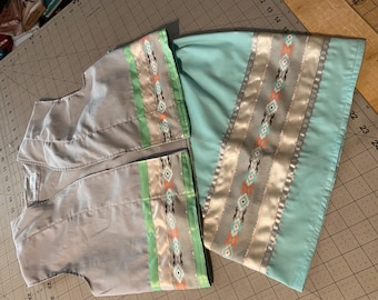 May include: A light gray vest and skirt set with decorative ribbon trim. The trim features a geometric pattern in shades of orange, gray, and teal, accented by green and silver stripes. The skirt is a solid teal color.