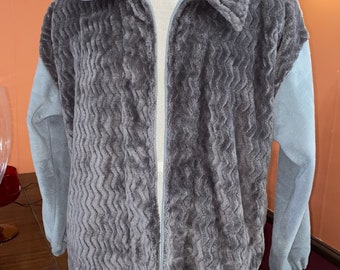 May include: A gray zip-up jacket with a textured, fuzzy fabric. The sleeves are a lighter gray color.