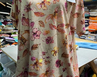 May include: A beige top and shorts set with a floral print in shades of pink, orange, and brown. The top has a scoop neck and short sleeves. The shorts have a wide waistband.