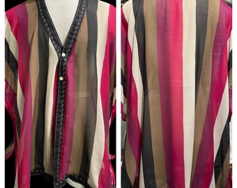 May include: A sheer, striped kimono with a button closure. The kimono is black, brown, white, and pink with a wavy trim.