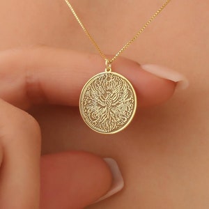 May include: A gold necklace with a round pendant featuring a detailed, intricate design. The pendant is a circle with a delicate, filigree pattern.