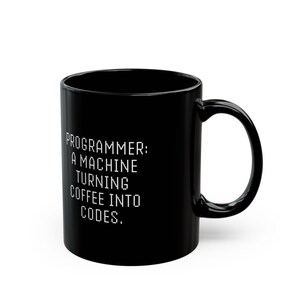 Peut inclure: Mug à café noir avec du texte blanc qui dit "PROGRAMMEUR : UNE MACHINE QUI TRANSFORME LE CAFÉ EN CODES."