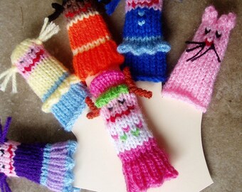 May include: A set of colorful finger puppets, including a girl with yellow hair, a girl with pink hair, a girl with blue hair, a girl with orange hair, a pink cat, and a girl with purple hair.