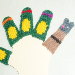 May include: Five finger puppets, four are green with yellow and orange accents, one is gray with black stripes and pink accents.