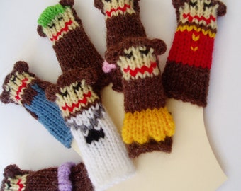 May include: Set of six knitted finger puppets, each with a different color and design. The puppets feature brown monkey faces with various expressions and colorful clothing.