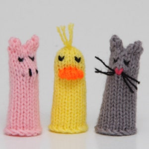 May include: Three knitted finger puppets: a pink pig, a yellow duck, and a gray cat. Each puppet has embroidered eyes and a simple facial expression.