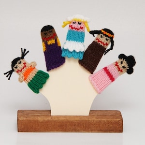May include: Five colorful finger puppets on a wooden stand. The puppets are made of knitted yarn and feature different facial expressions and hairstyles. The puppets are a great way to encourage imaginative play and storytelling.