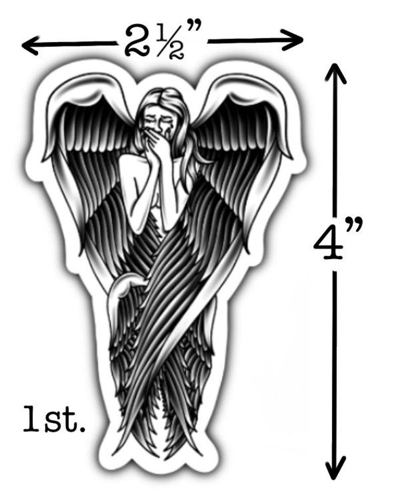 May include: A black and white sticker featuring a crying angel with large wings. The sticker is 4 inches (10 cm) tall and 2.5 inches (6.35 cm) wide. The text "1st." is at the bottom.