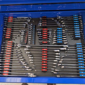 May include: A blue toolbox drawer filled with a comprehensive set of wrenches. The wrenches are neatly organized on a black foam insert, with sizes clearly labeled in inches. The tools are made of shiny metal.