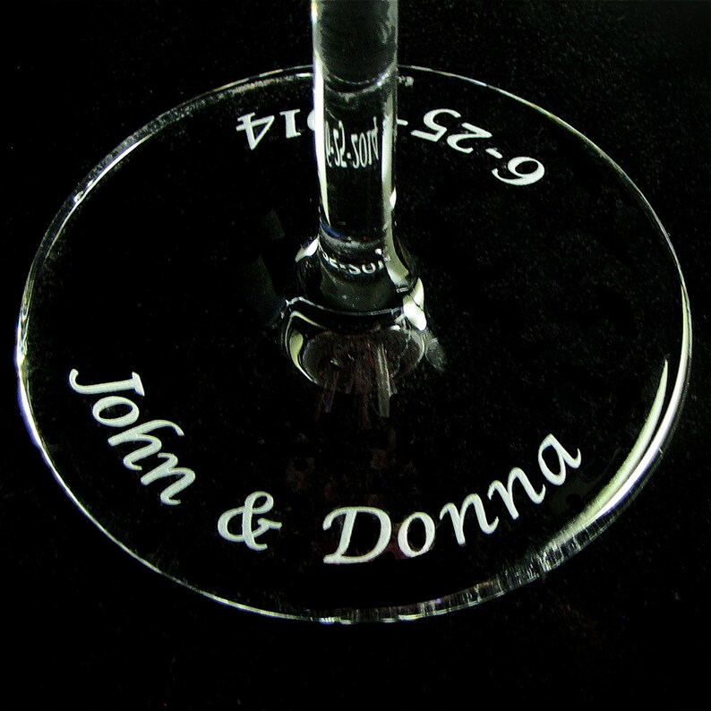 A clear glass wine glass with the names and wedding date engraved.