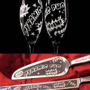 May include: A set of two champagne flutes and a cake server with a comic book theme. The glasses and server are engraved with the words "Dynamic Duo" and various comic book sound effects like "Pow!" and "Zap!"