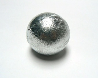 May include: A silver-colored metal sphere with a smooth, slightly textured surface.