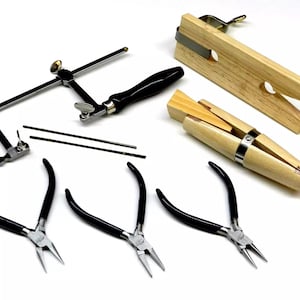 Op de afbeelding: Een sieradenmaakset met een zaagframe, zaagbladen, drie tangenparen en twee houten ringmandrels.