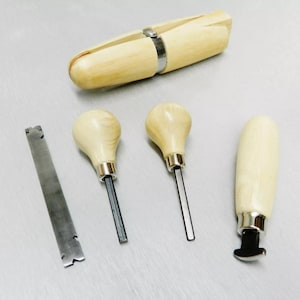 May include: A set of five wooden tools for jewelry making. The set includes a ring mandrel, two wooden handled tools with metal tips, a metal scraper, and a wooden handled tool with a metal ring cutter.